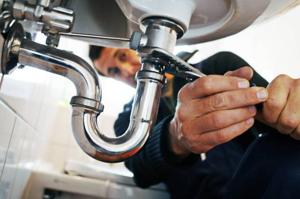 Plumber repairing sink pipes